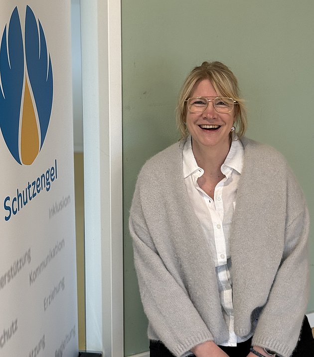 Das Bild zeigt die Familienkrankenschwester Frau Julia Kuntze neben einem Schutzengel-Logo